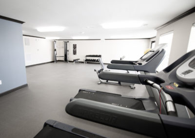 Fitness Center at Goodnight Commons with three treadmills, free weights, and a cable machine