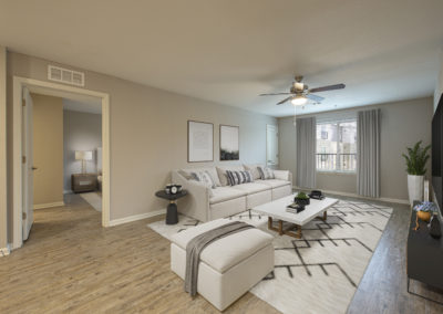 Model apartment living room with large decorated windows and comfortable seating area