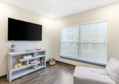 Model Austin, TX apartment living area with an extra large window, television, an sitting area